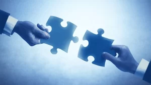 Two puzzle pieces about to be connected, representing integration for automated rostering