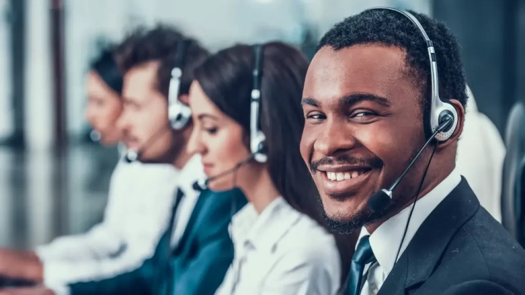Smiling man with earphones providing customer support